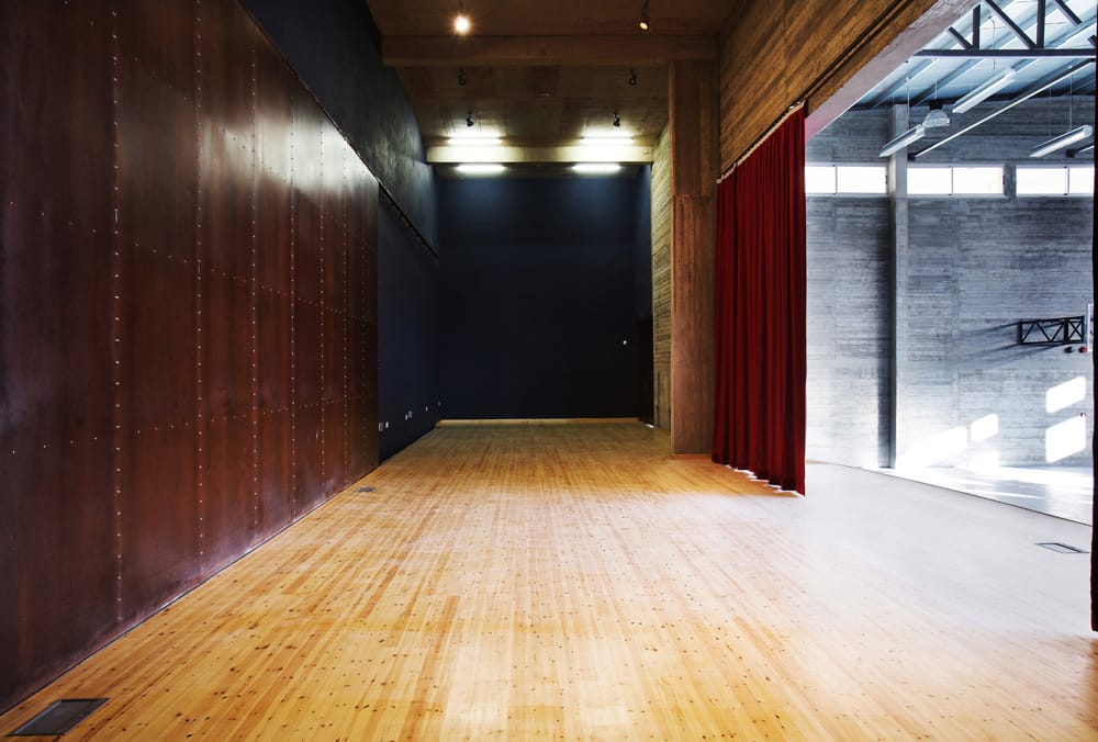 Η σκηνή και τα παρασκήνια της αίθουσας πολλαπλών χρήσεων.  Οι μεγάλες συρόμενες πόρτες στα αριστερά όταν ανοίγουν επιτρέπουν τη χρήση της σκηνής από το υπαίθριο θέατρο, © Χρίστος Παπαντωνίου